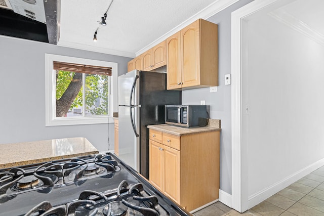 kitchen featuring light brown cabinetry, appliances with stainless steel finishes, crown molding, and baseboards