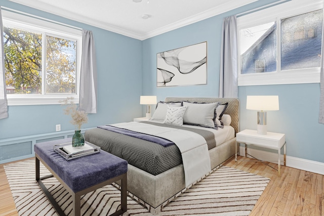 bedroom featuring baseboards, wood finished floors, and crown molding