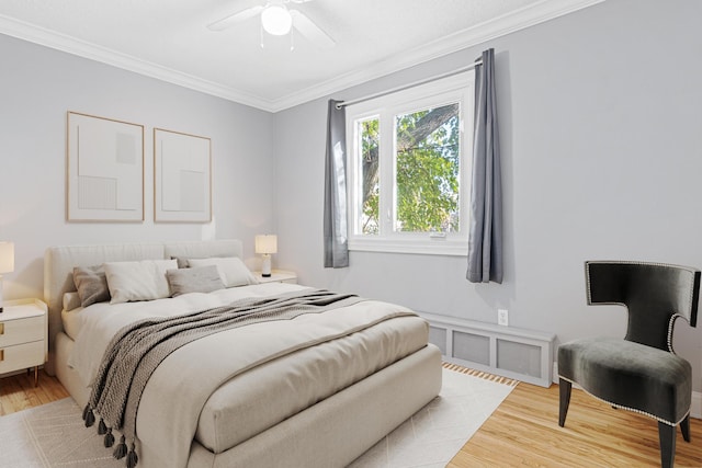 bedroom with a ceiling fan, light wood finished floors, and ornamental molding