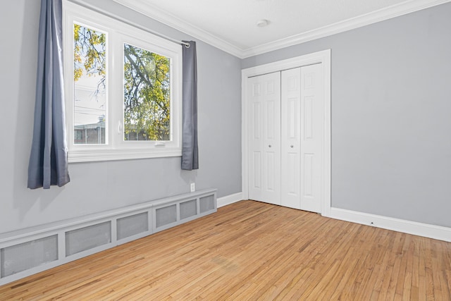 unfurnished bedroom featuring light wood-style flooring, baseboards, a closet, and ornamental molding