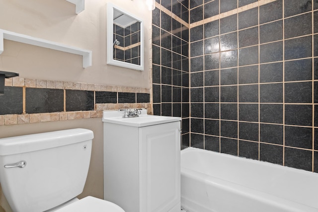 bathroom featuring vanity, tile walls, and toilet