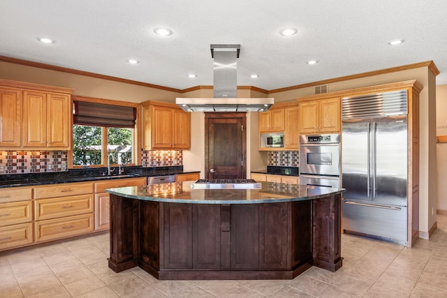 kitchen featuring visible vents, island exhaust hood, tasteful backsplash, a center island, and built in appliances