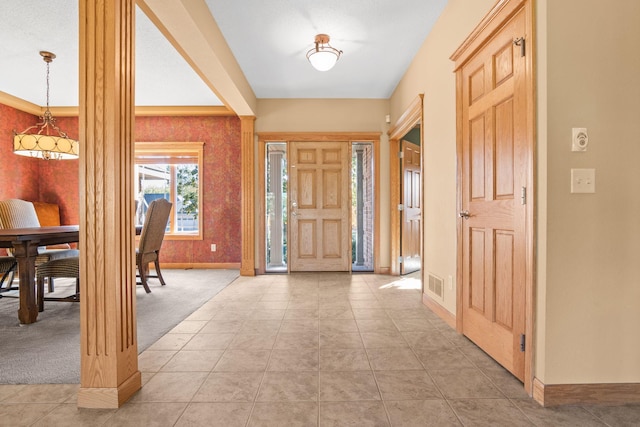 entrance foyer with light tile patterned floors, visible vents, baseboards, and light carpet