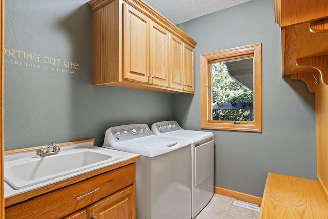 laundry room with visible vents, a sink, washer and dryer, cabinet space, and baseboards