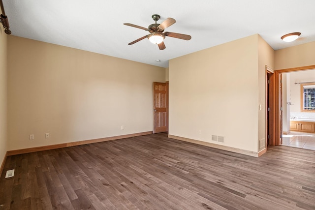 unfurnished room featuring visible vents, baseboards, and wood finished floors