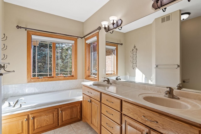 bathroom with tile patterned floors, a garden tub, visible vents, and a sink