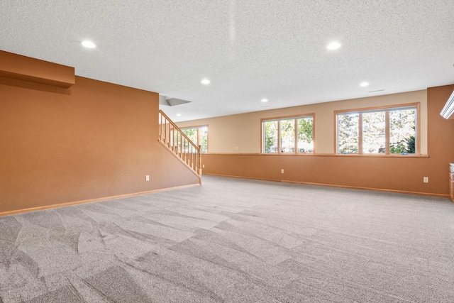 spare room with recessed lighting, baseboards, light carpet, and stairs