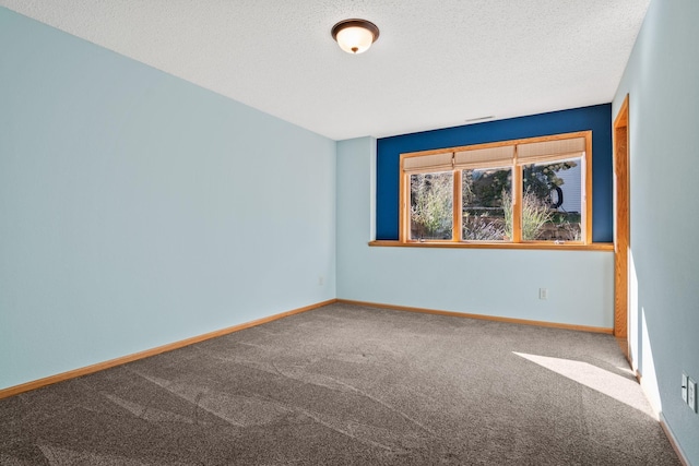 empty room with baseboards, carpet floors, and a textured ceiling