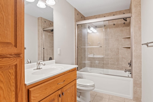 bathroom with tile patterned floors, combined bath / shower with glass door, toilet, and vanity