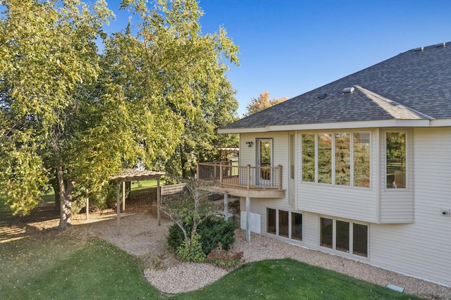 rear view of house featuring roof with shingles and a patio area