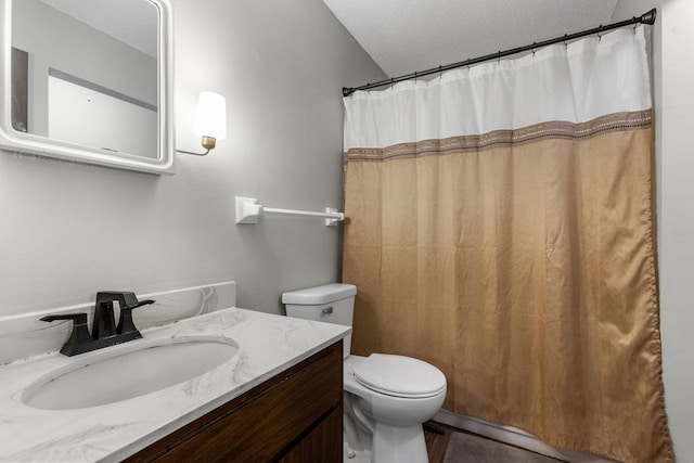 bathroom featuring curtained shower, toilet, vanity, and a textured ceiling