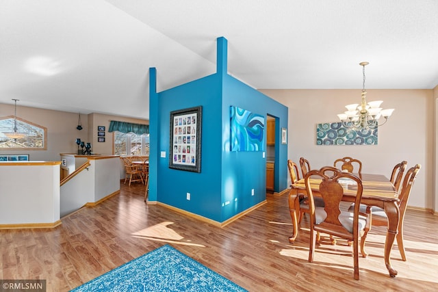 dining room with a notable chandelier, wood finished floors, and baseboards