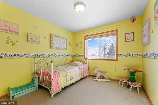 carpeted bedroom featuring baseboards and a textured ceiling