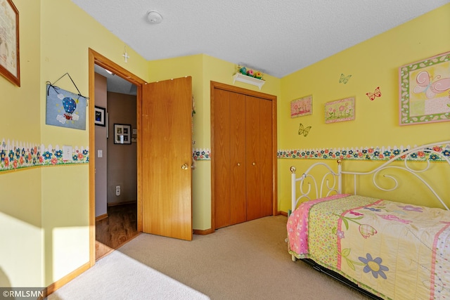 bedroom featuring a closet, a textured ceiling, and carpet