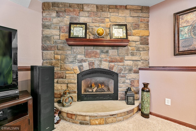 interior details featuring baseboards and a stone fireplace