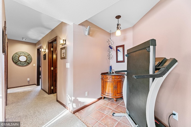 workout area with tile patterned floors, carpet flooring, and baseboards