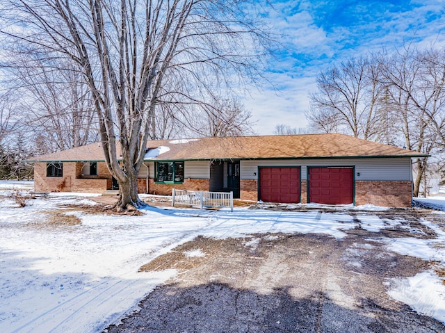 ranch-style home with driveway, brick siding, and an attached garage