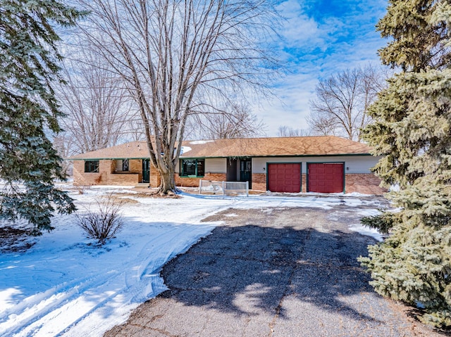 view of front of property with a garage, brick siding, and driveway