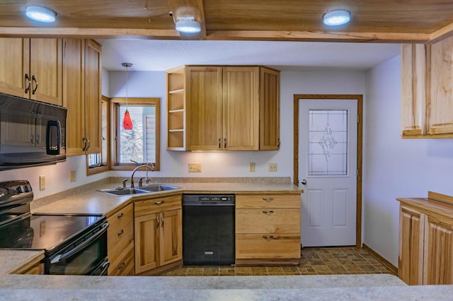 kitchen with black appliances, decorative light fixtures, light countertops, and a sink