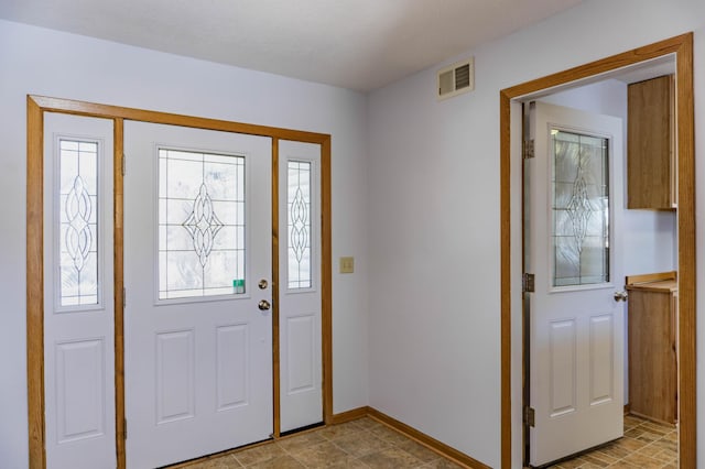 foyer entrance with visible vents and baseboards