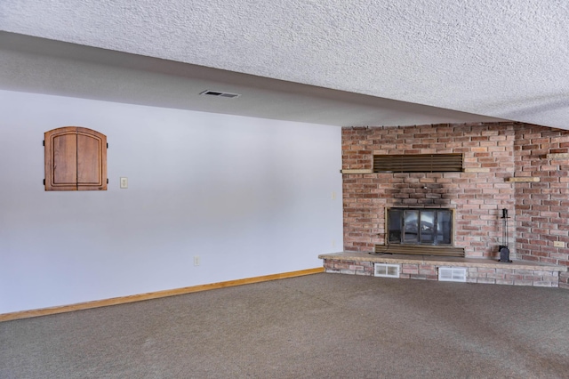 unfurnished living room with visible vents, a textured ceiling, a brick fireplace, and carpet flooring