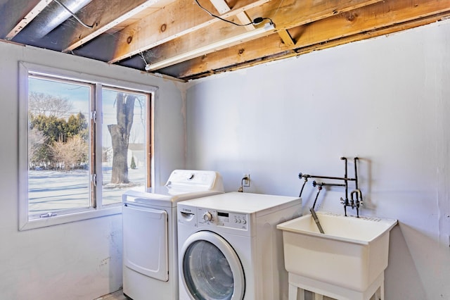 laundry area with independent washer and dryer and a sink