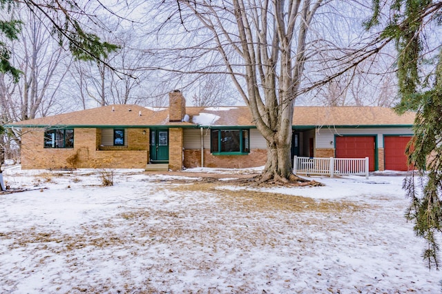 ranch-style house with brick siding, an attached garage, and a chimney