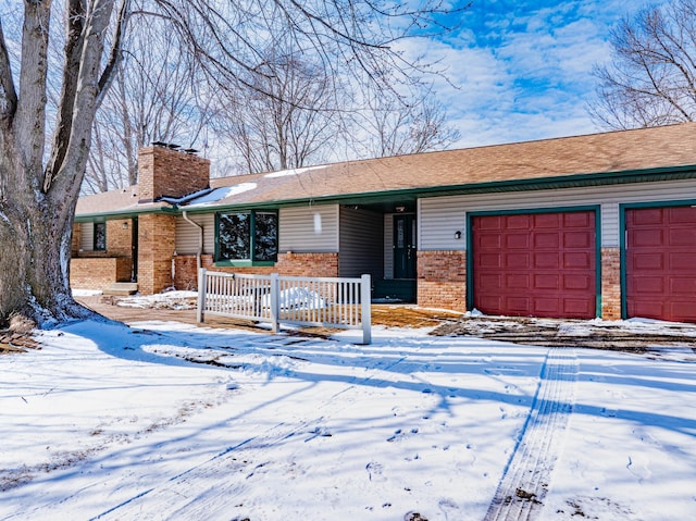 ranch-style home featuring brick siding, covered porch, an attached garage, and a chimney