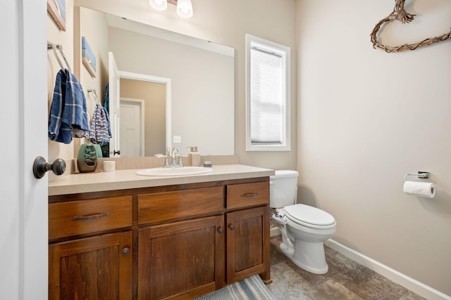 half bathroom with baseboards, toilet, and vanity