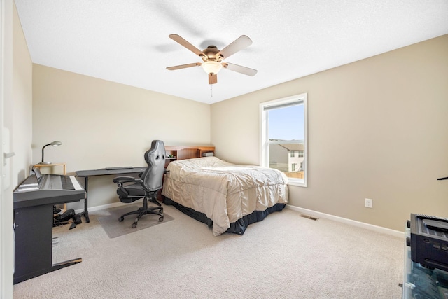 carpeted bedroom featuring visible vents, baseboards, a textured ceiling, and a ceiling fan