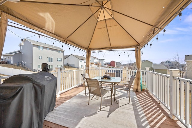 deck with outdoor dining area, a residential view, and grilling area