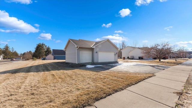 view of side of property with a garage and a lawn