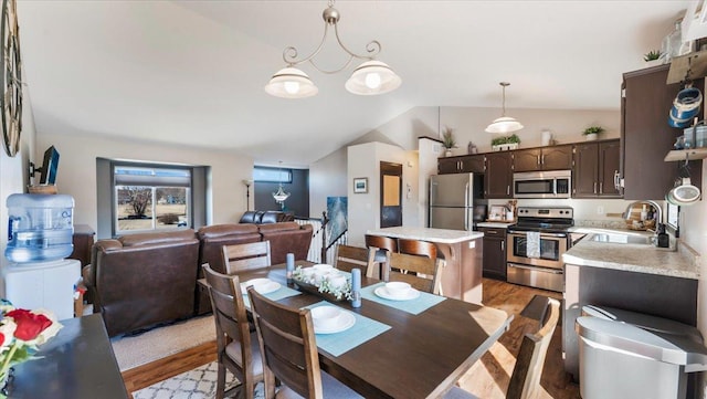 dining space with lofted ceiling and light wood-style flooring