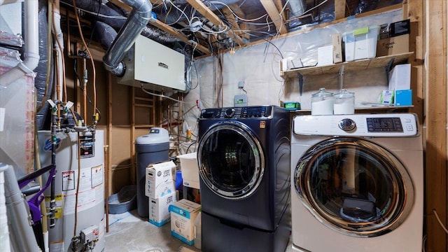 clothes washing area with laundry area, gas water heater, and washing machine and dryer