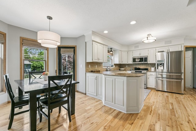 2415 Field Ct, Saint Cloud, MN 56301 - kitchen with stainless steel appliances, light wood-style floors, backsplash, a sink, and recessed lighting