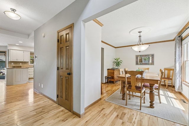 2415 Field Ct, Saint Cloud, MN 56301 - dining room with light wood-style floors, baseboards, and crown molding