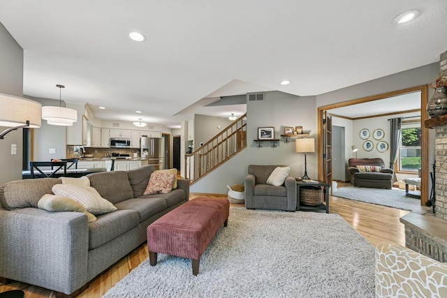 2415 Field Ct, Saint Cloud, MN 56301 - living area featuring light wood finished floors, stairs, a large fireplace, and recessed lighting