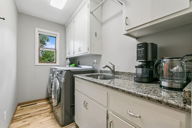 2415 Field Ct, Saint Cloud, MN 56301 - laundry room featuring light wood-style flooring, cabinet space, washer and dryer, and baseboards