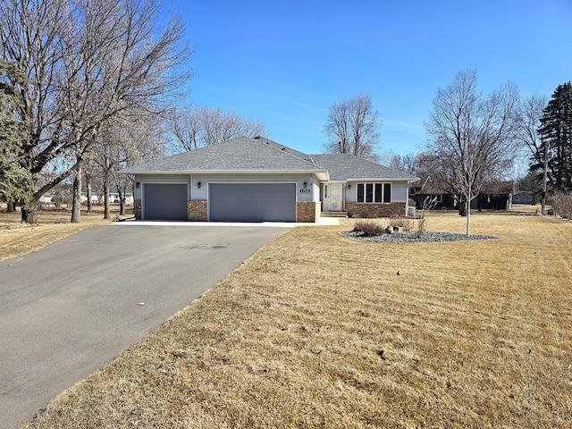 single story home featuring a garage, brick siding, a front lawn, and aphalt driveway