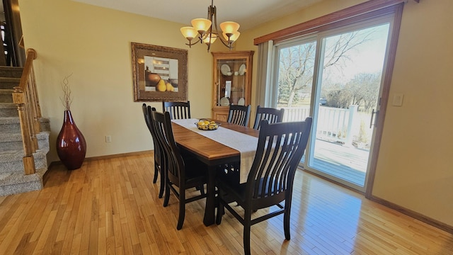 dining area with stairs, an inviting chandelier, light wood-style floors, and baseboards