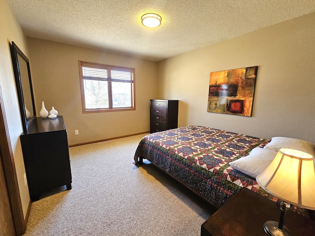 carpeted bedroom featuring a textured ceiling and baseboards