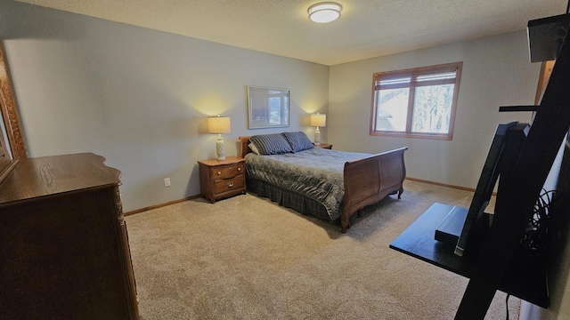 bedroom with light carpet, a textured ceiling, and baseboards