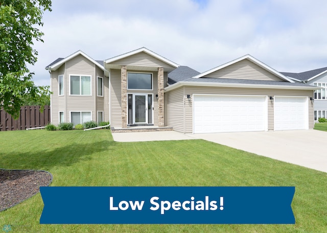 view of front of property with an attached garage, concrete driveway, a front lawn, and fence