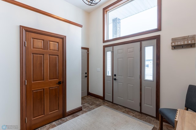 entrance foyer with stone finish flooring and baseboards