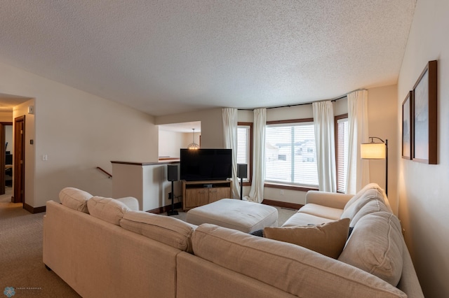 carpeted living area featuring baseboards and a textured ceiling