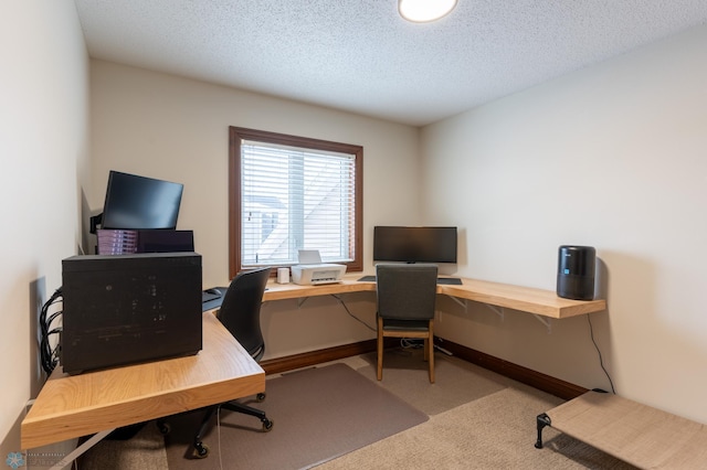 carpeted home office with a textured ceiling and baseboards