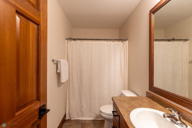 full bath featuring toilet, vanity, and a textured ceiling