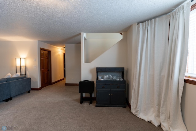 interior space with baseboards, carpet floors, and a textured ceiling