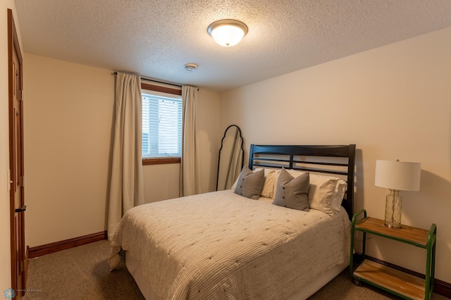 carpeted bedroom with a textured ceiling and baseboards