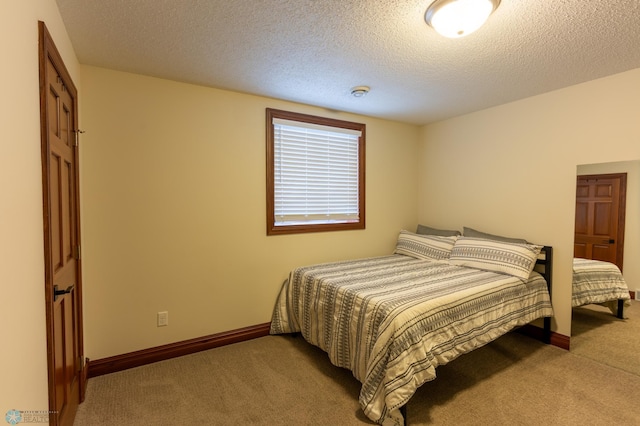 bedroom featuring baseboards, a textured ceiling, and carpet flooring